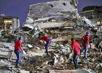Einsatzkräfte klettern über Schuttberge in der Dunkelheit im Erdbebengebiet in Venezuela.