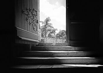 Vier Treppenstufen, die zu einer offenen Tür führen.