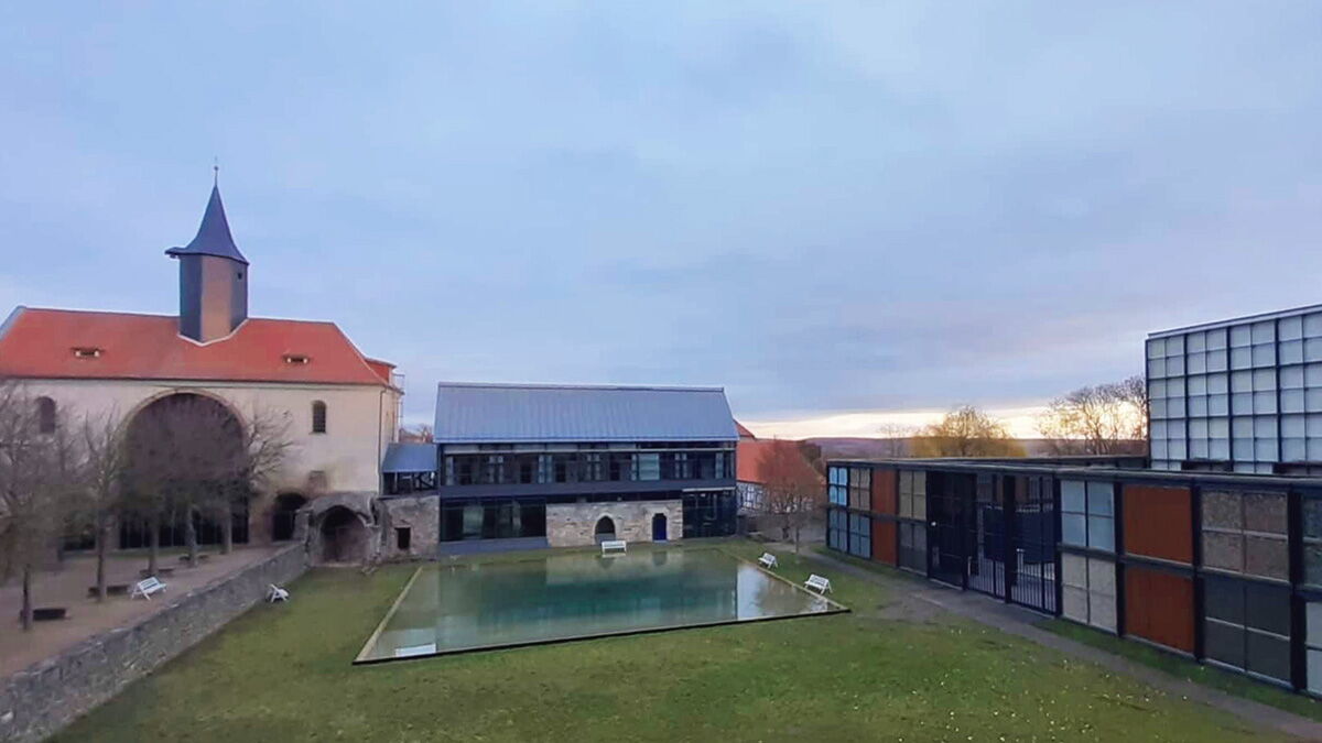 Blick auf die Klosteranlage in Volkenroda im Morgenlicht mit der Kapelle im Hintergrund.