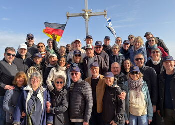 Eine Gruppe von rund 35 Personen steht dicht beieinander auf einem Boot des Sees Genezareth.