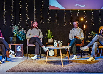 Vier Menschen auf einer Bühne sitzen in vier Sesseln