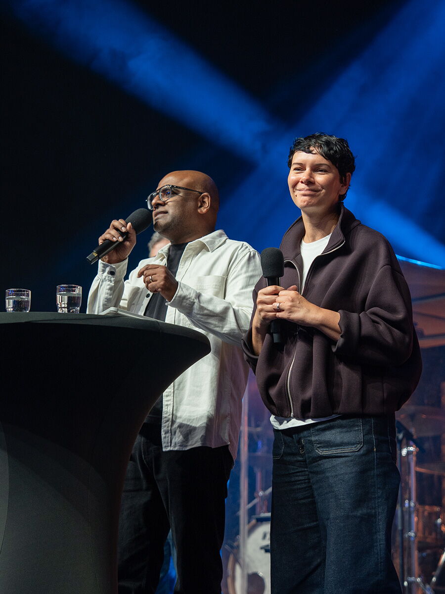 Sharon und Joel Chelliah stehen mit Mikrofonen gemeinsam auf der Bühne der BFP-Bundeskonferenz.